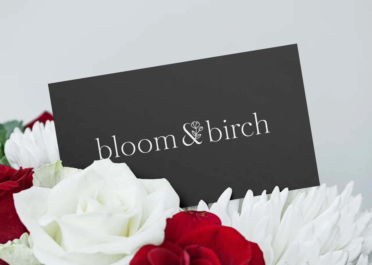 Bloom and Birch branded card nestled among flowers